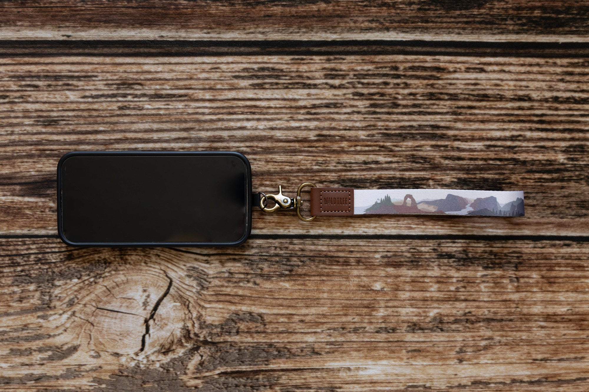 Keychain with a desert landscape design on a wooden surface