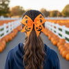 orange bow with jack o lantern designs, and cat silhouettes, halloween