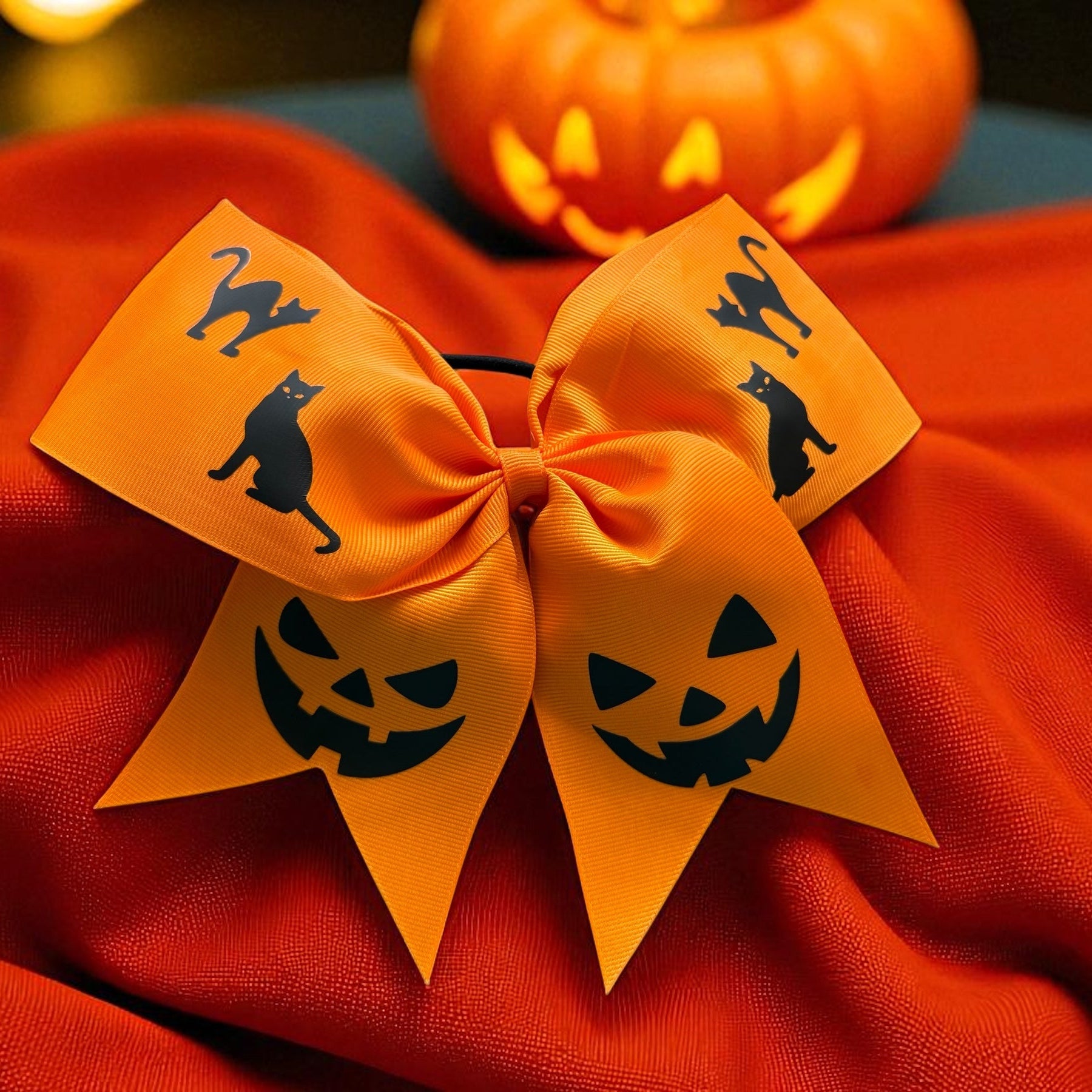 orange bow with jack o lantern designs, and cat silhouettes, halloween