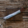 Knife with a leather sheath on a wooden surface